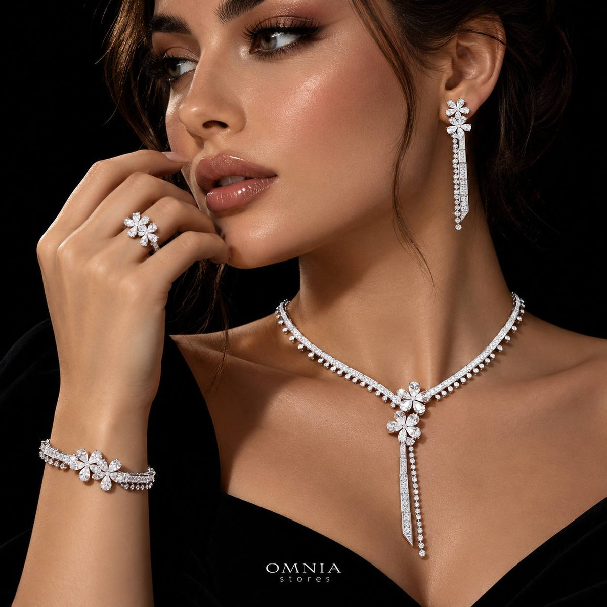 Model wearing the Omnia Emmeline white zircon bridal jewellery set with floral necklace, long earrings, bracelet and ring